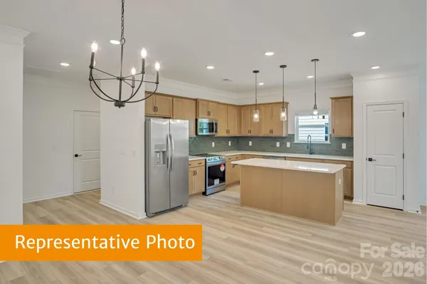 a kitchen with stainless steel appliances granite countertop a refrigerator a sink and a stove