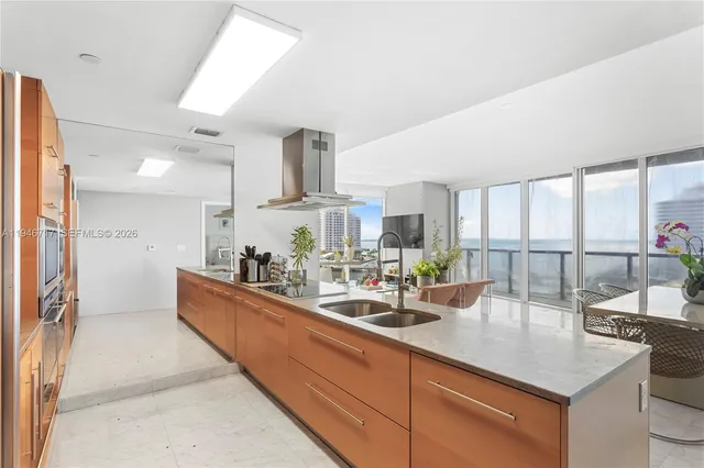 a kitchen with stainless steel appliances granite countertop a refrigerator a stove and a sink with wooden floor