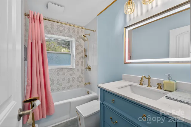 a bathroom with a granite countertop sink a mirror and a bathtub