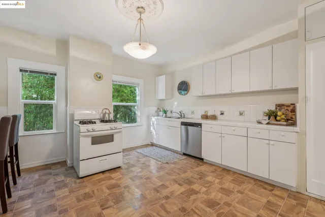a kitchen with granite countertop white cabinets and white appliances