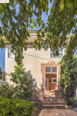 a front view of a house with a tree