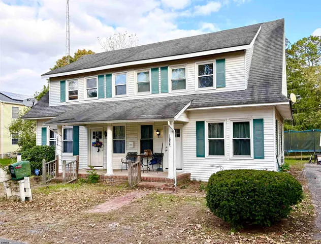 a front view of a house with a garden and porch
