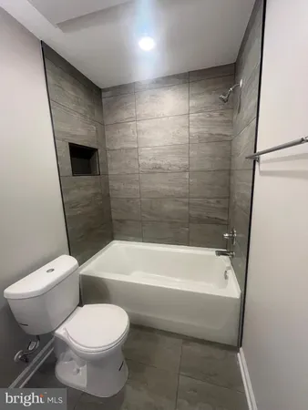 a bathroom with a toilet and a bath tub