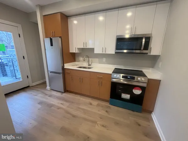 a kitchen with stainless steel appliances a stove a microwave a sink and a refrigerator