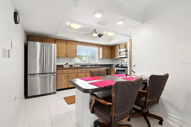 a kitchen with a refrigerator a stove a kitchen island with a dining table and chairs