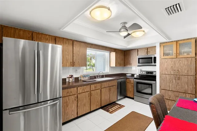 a kitchen with stainless steel appliances granite countertop a refrigerator sink and stove