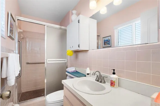 a bathroom with a sink a toilet and shower