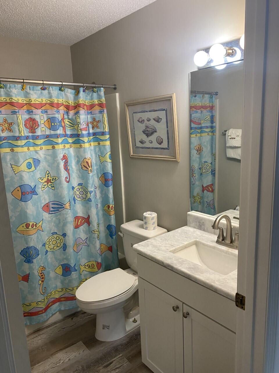 285 Payne Street, Unit 4B Miramar Beach, FL 32550 - Photo 11 of 12 a bathroom with a sink a toilet and shower curtain