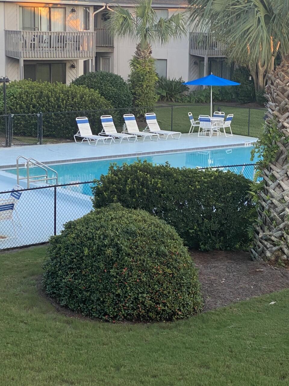 285 Payne Street, Unit 4B Miramar Beach, FL 32550 - Photo 12 of 12 a view of a garden with a bench and trees in the background