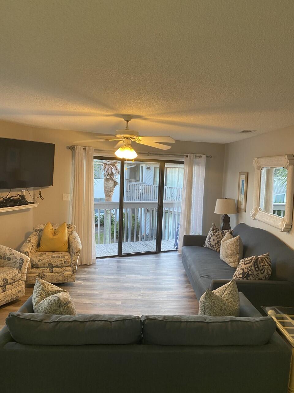 285 Payne Street, Unit 4B Miramar Beach, FL 32550 - Photo 3 of 12 a living room with furniture and a flat screen tv
