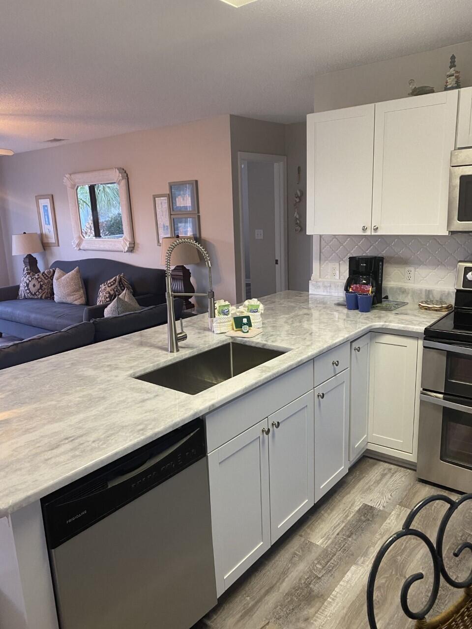 285 Payne Street, Unit 4B Miramar Beach, FL 32550 - Photo 5 of 12 a kitchen with a sink dishwasher and cabinets