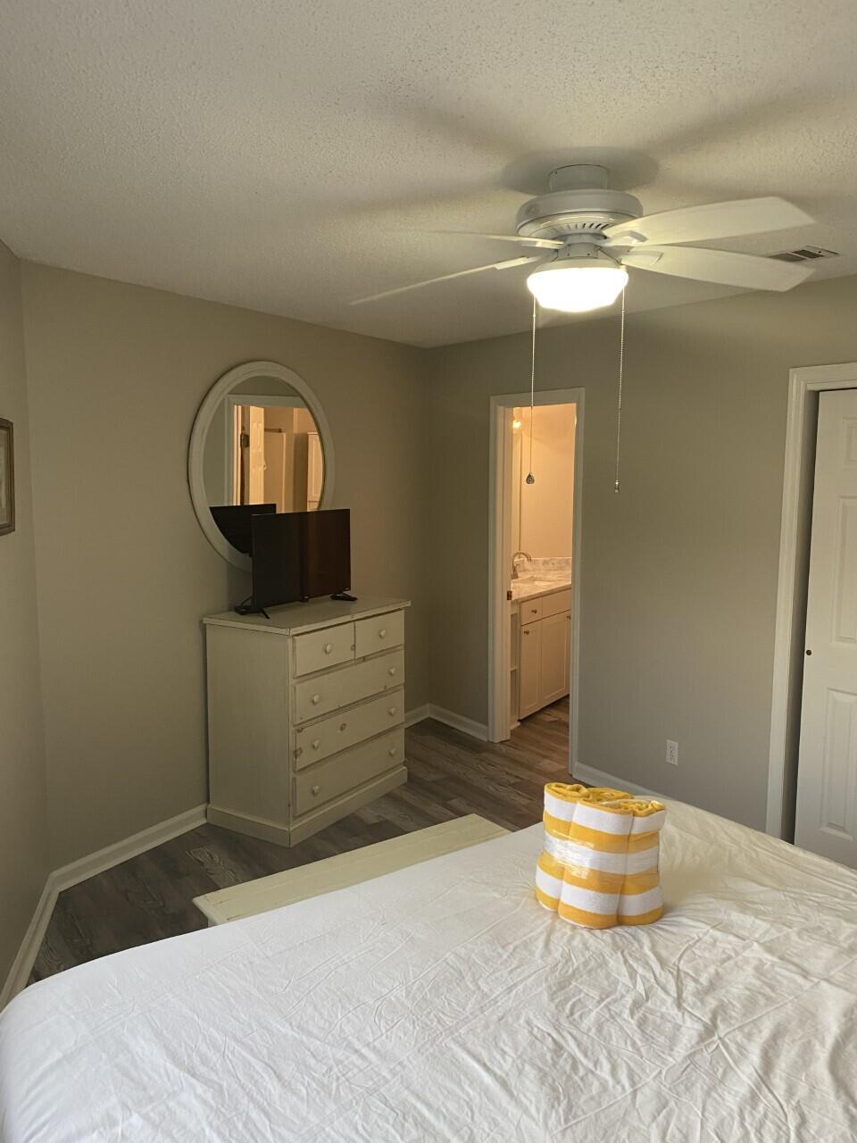 285 Payne Street, Unit 4B Miramar Beach, FL 32550 - Photo 7 of 12 a bedroom with a bed and a chandelier