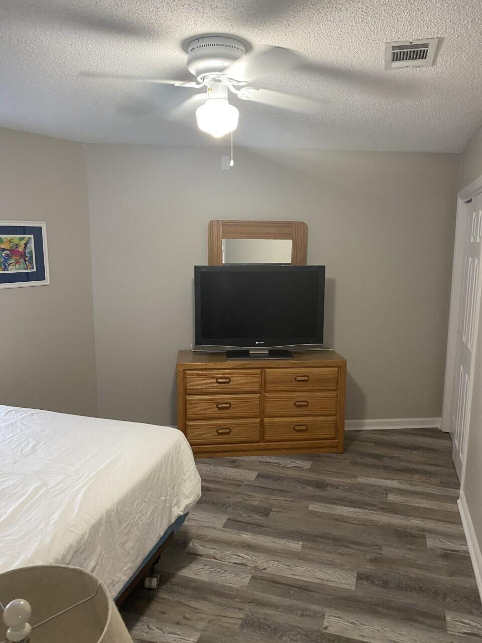 285 Payne Street, Unit 4B Miramar Beach, FL 32550 - Photo 9 of 12 a bedroom with a bed and a chandelier