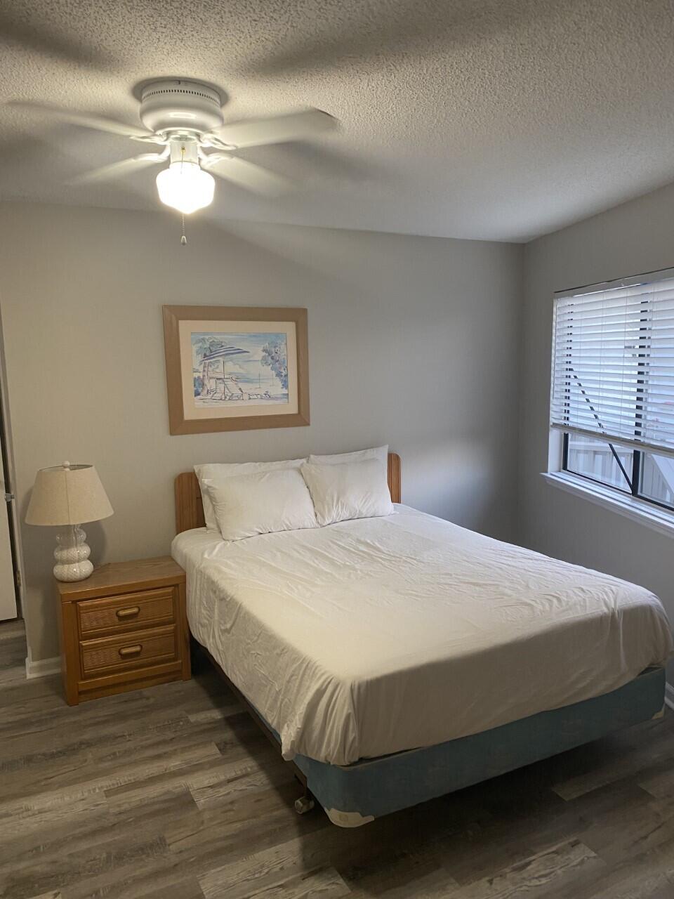 285 Payne Street, Unit 4B Miramar Beach, FL 32550 - Photo 10 of 12 a bedroom with a bed and a chandelier