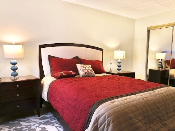 16 Winter Street, Unit 43B Waltham, MA 02451 - Photo 7 of 12 a bedroom with a bed and a lamp on dresser