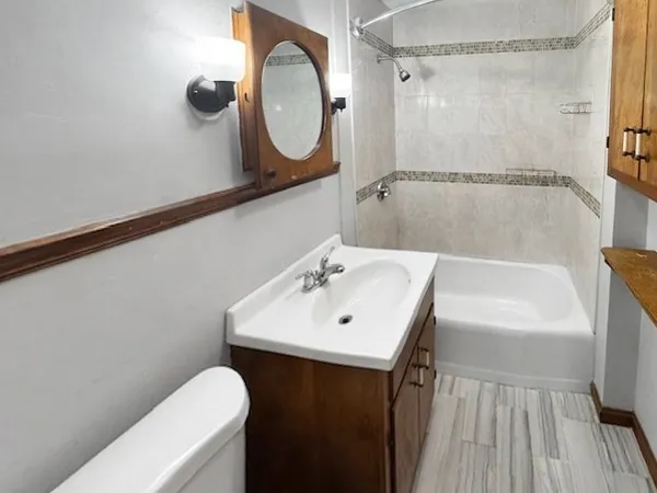 a bathroom with a sink mirror vanity and toilet
