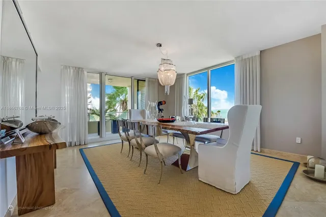 a living room with furniture a large window and a dining table