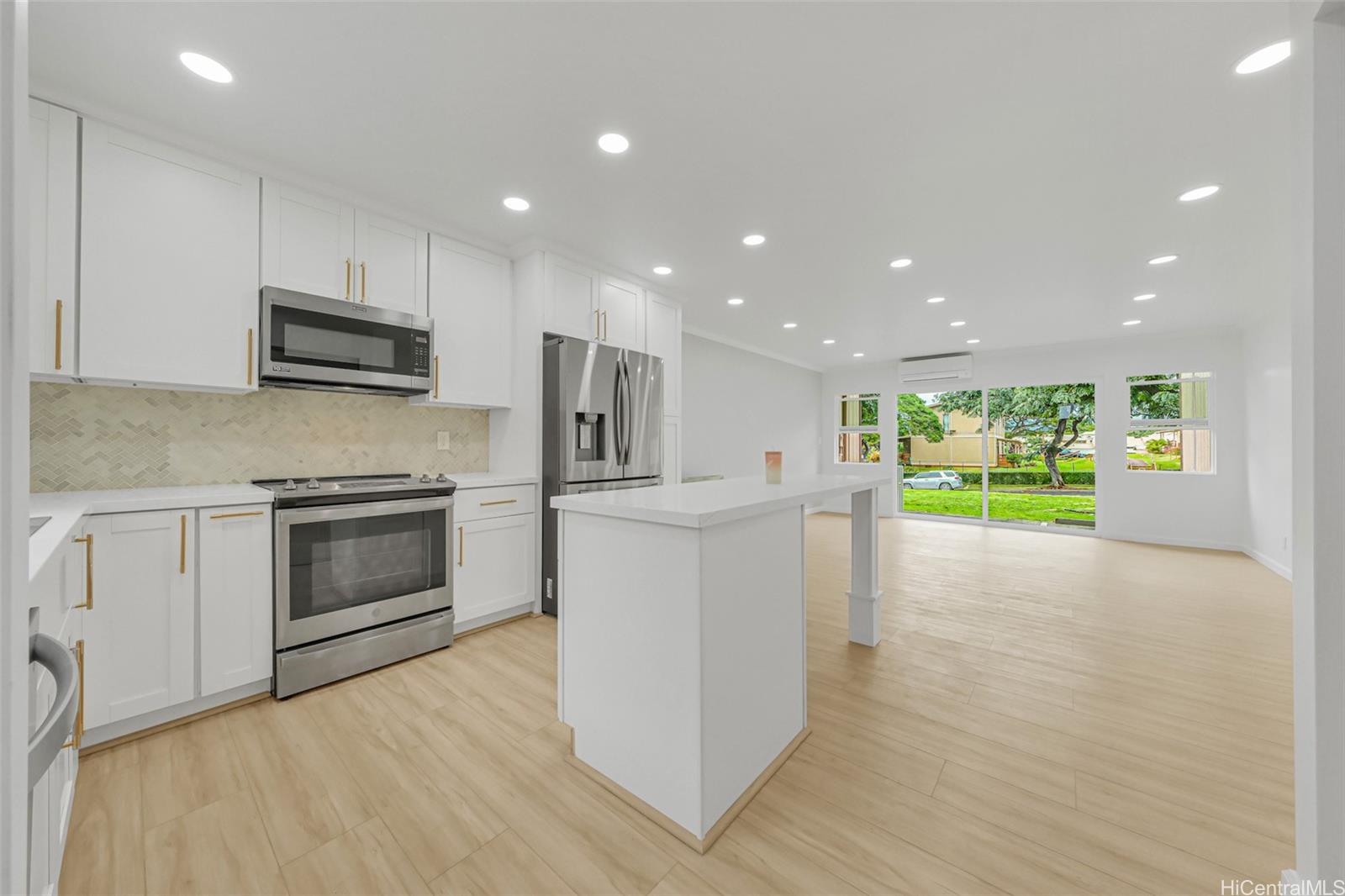 a kitchen with stainless steel appliances kitchen island granite countertop a stove top oven a sink and a microwave