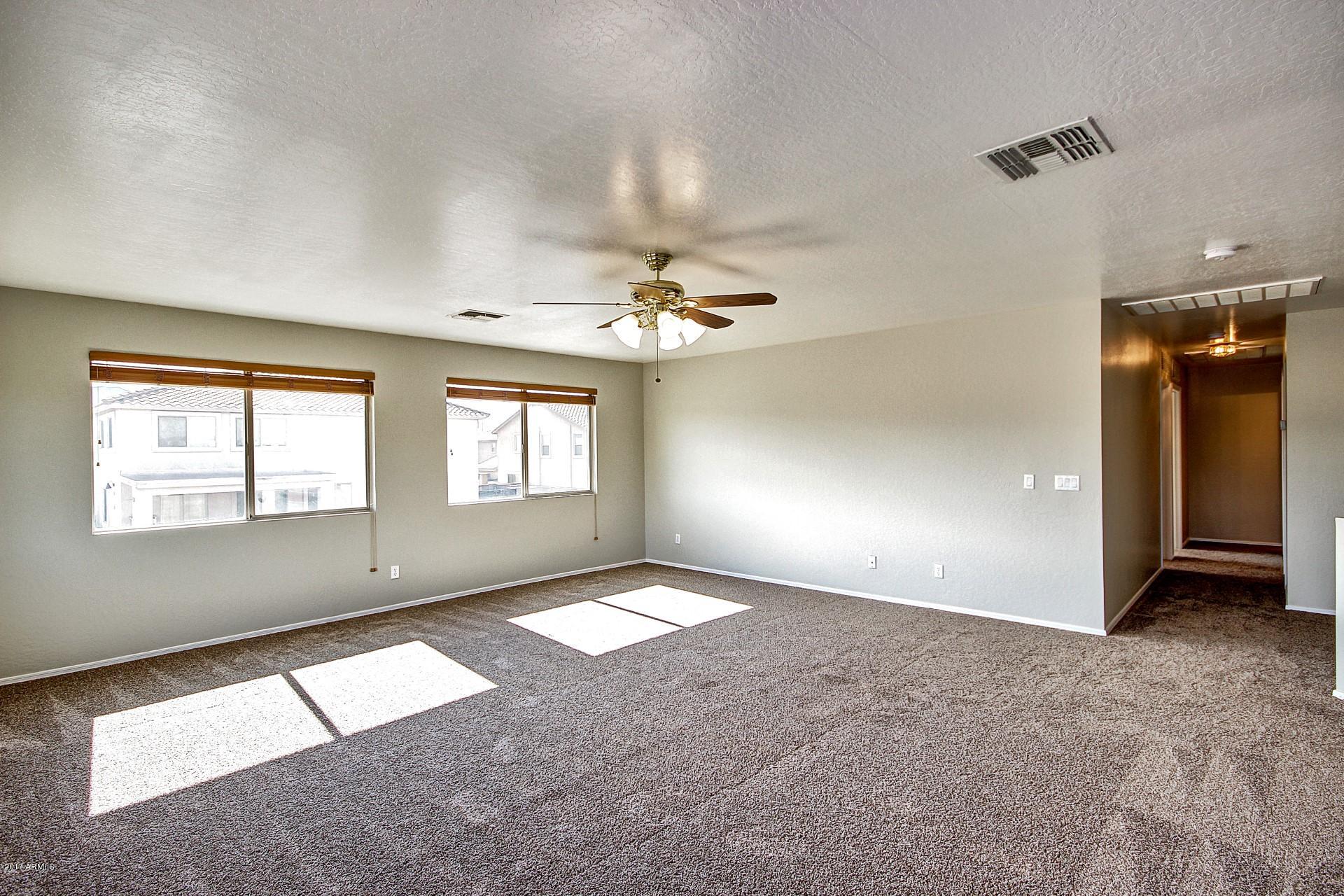 2907 West Carson Road Phoenix, AZ 85041 - Photo 12 of 27 an empty room with windows and fan