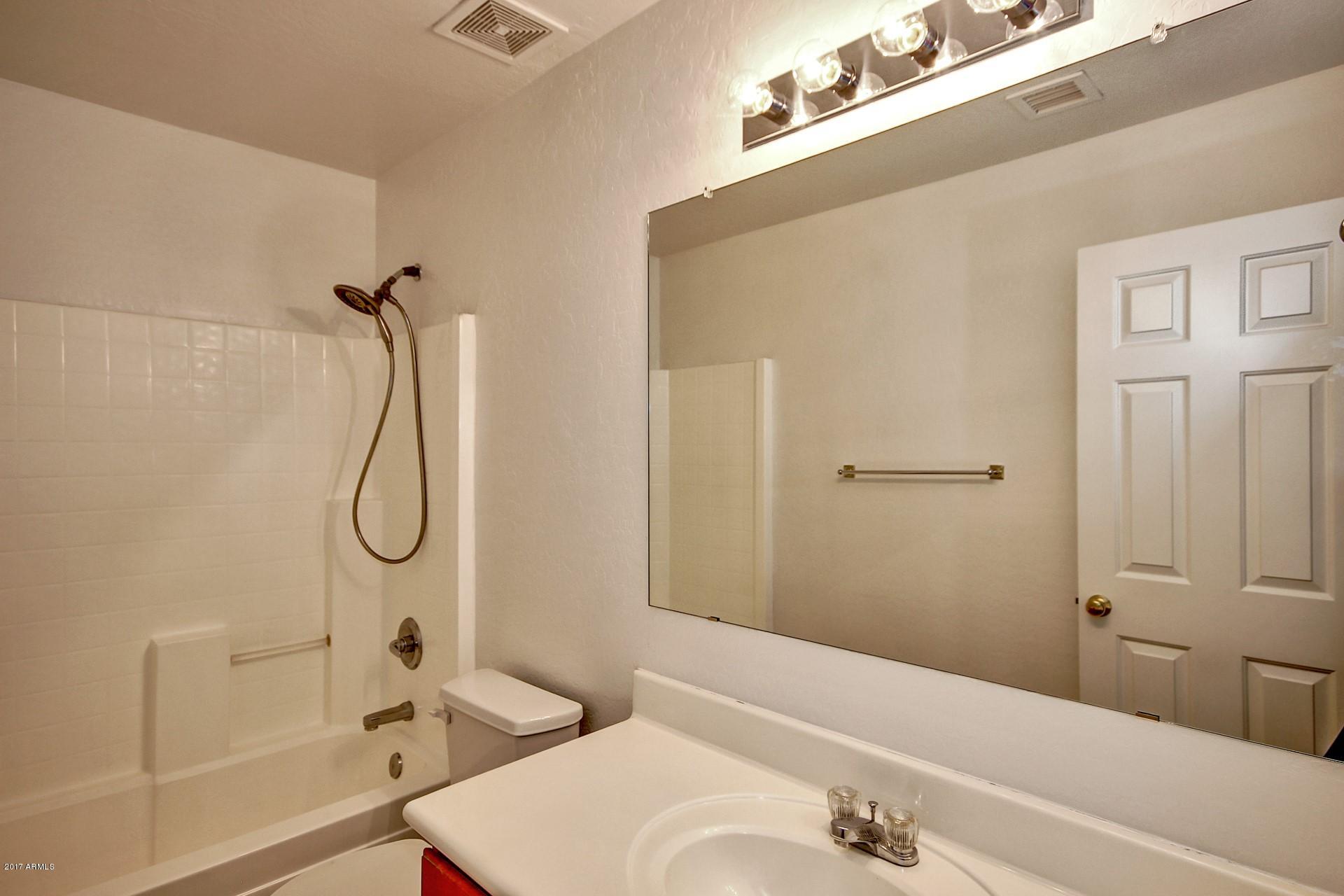 2907 West Carson Road Phoenix, AZ 85041 - Photo 24 of 27 a bathroom with a granite countertop sink a toilet and shower