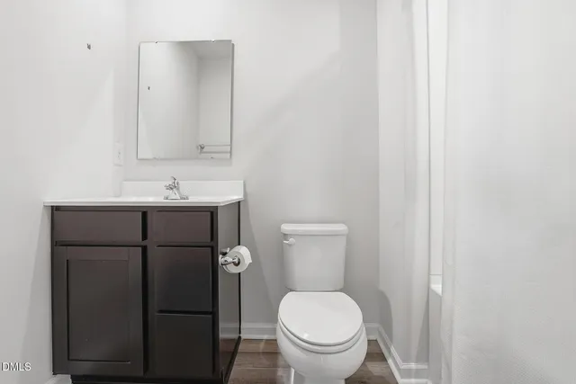 a bathroom with a toilet a sink and mirror