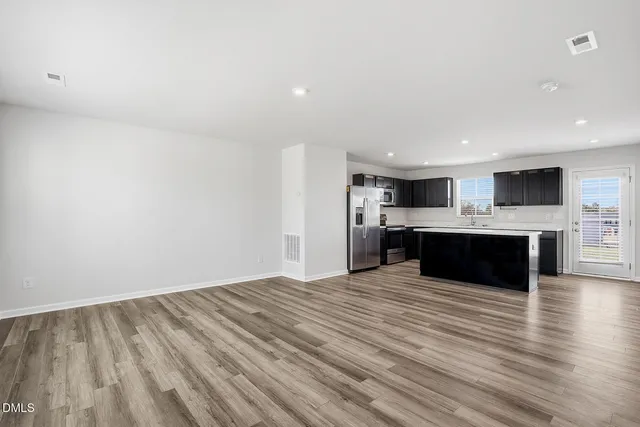 a large kitchen with kitchen island a sink stainless steel appliances and cabinets
