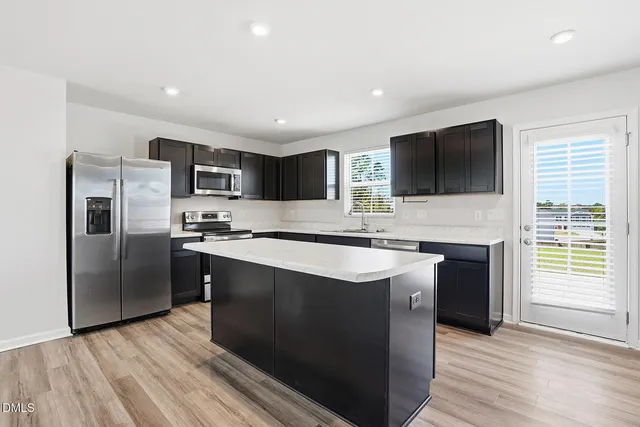 a kitchen with stainless steel appliances granite countertop a sink stove and refrigerator