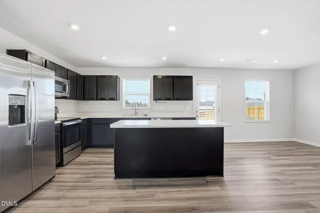 a kitchen with a refrigerator and a stove top oven