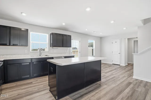 a kitchen with a sink cabinets and wooden floor