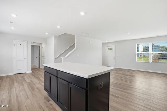 a kitchen with a wooden floor and electronic appliances