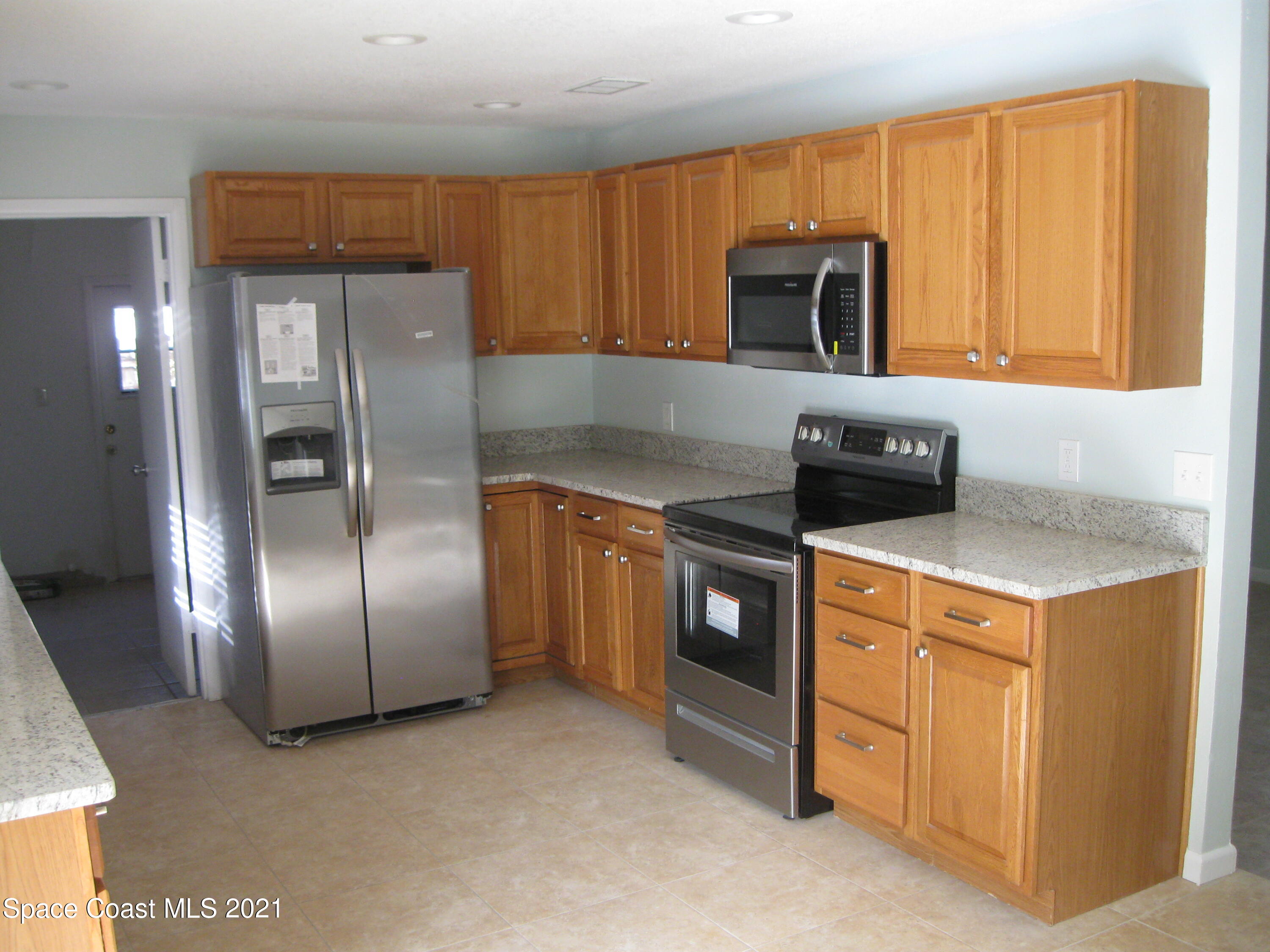 770 Sandgate Street Merritt Island, FL 32953 - Photo 7 of 22 a kitchen with stainless steel appliances granite countertop a refrigerator a stove a sink and a microwave