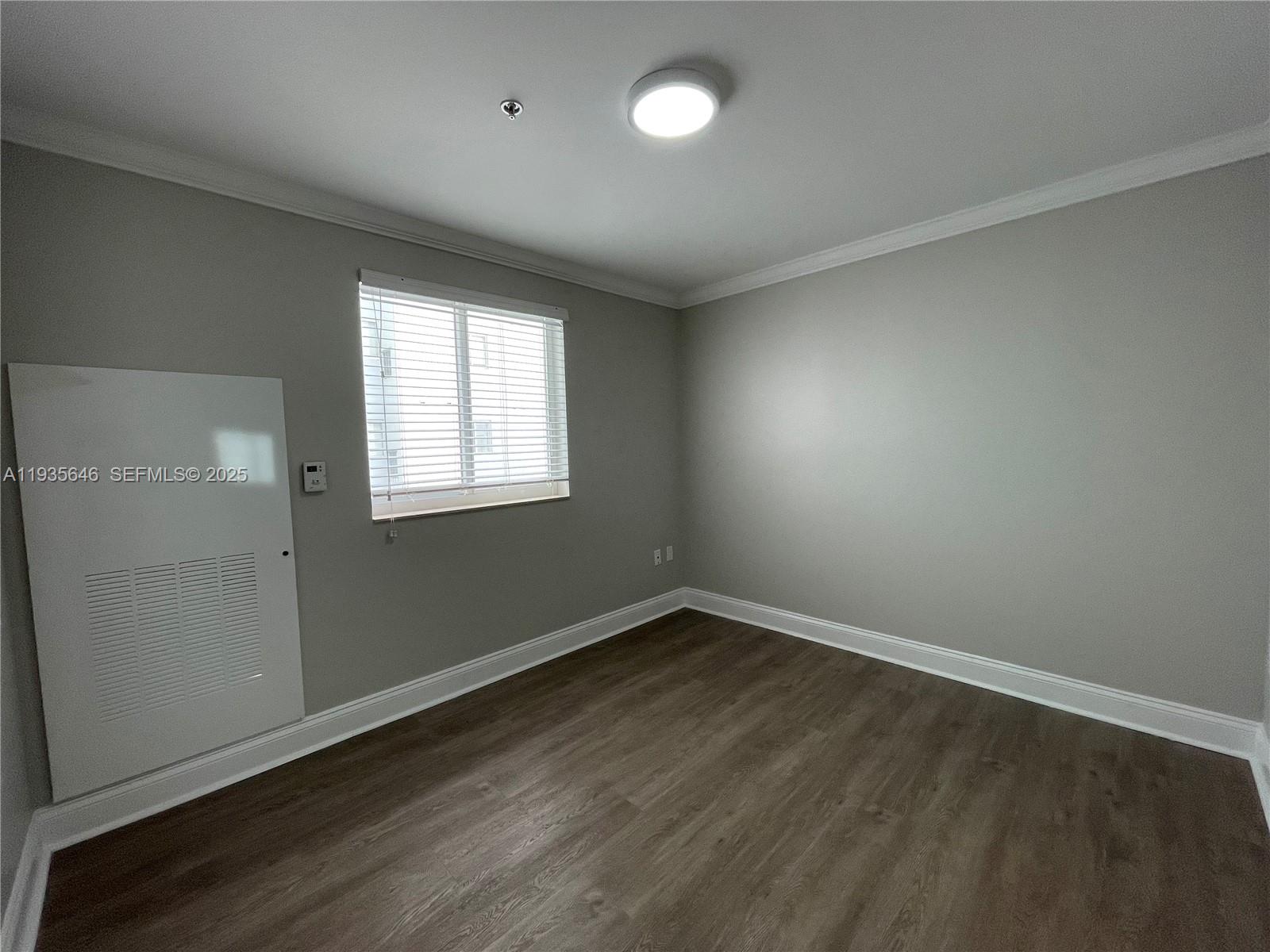 1750 Northwest 107th Avenue, Unit R508 Sweetwater, FL 33172 - Photo 8 of 15 an empty room with wooden floor and windows