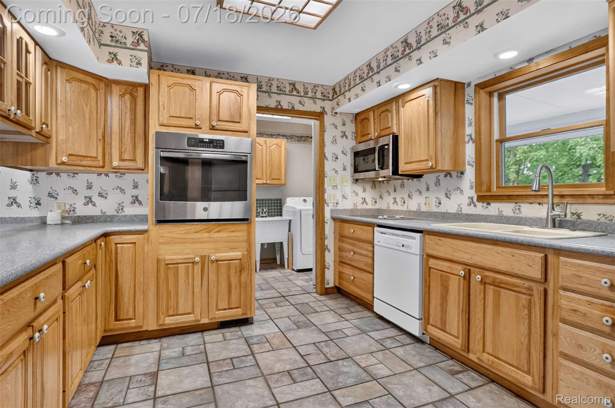 1437 East Cook Road Grand Blanc, MI 48439 - Photo 44 of 69 Kitchen featuring abundant wood cabinetry, gray-flecked countertops, and a tiled floor