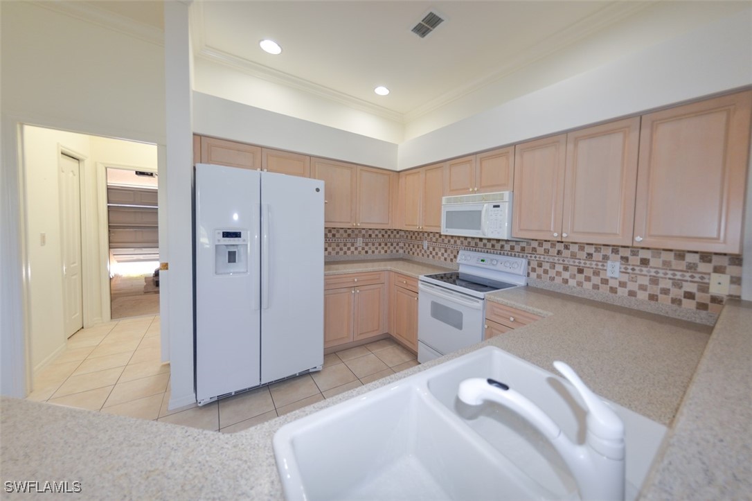 11142 Wine Palm Road Fort Myers, FL 33966 - Photo 11 of 42 a kitchen with a white cabinets and white appliances