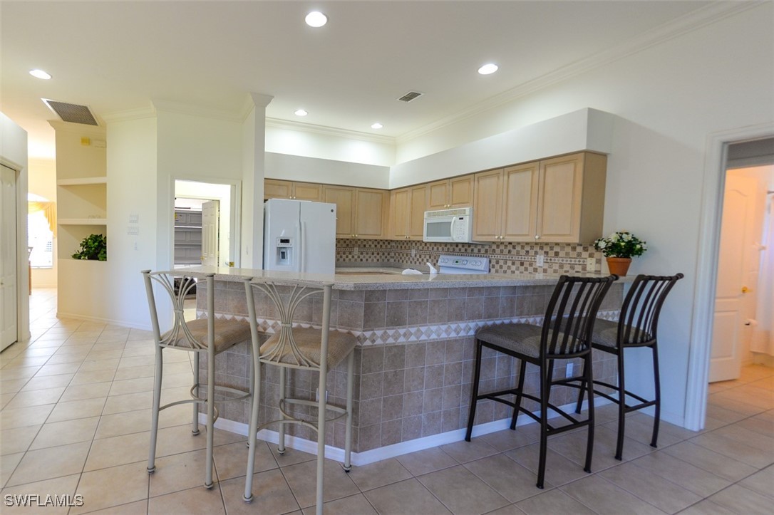 11142 Wine Palm Road Fort Myers, FL 33966 - Photo 13 of 42 a kitchen with granite countertop cabinets and chairs in it