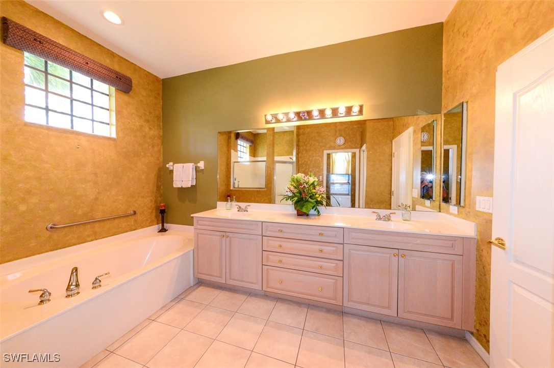 11142 Wine Palm Road Fort Myers, FL 33966 - Photo 24 of 42 a spacious bathroom with a tub sink and mirror
