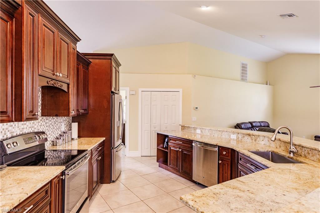 3881 Packinghouse Road Alva, FL 33920 - Photo 12 of 35 a kitchen with stainless steel appliances granite countertop a stove a sink and a refrigerator