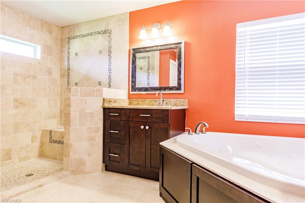 3881 Packinghouse Road Alva, FL 33920 - Photo 17 of 35 a bathroom with a granite countertop sink a mirror and a shower