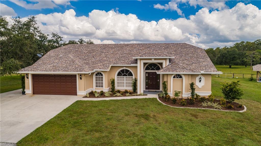 3881 Packinghouse Road Alva, FL 33920 - Photo 2 of 35 a front view of a house with garden