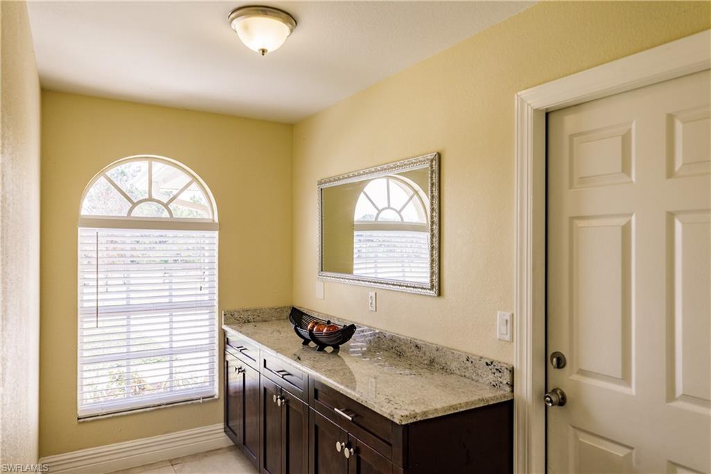 3881 Packinghouse Road Alva, FL 33920 - Photo 30 of 35 a bathroom with a granite countertop sink and a window