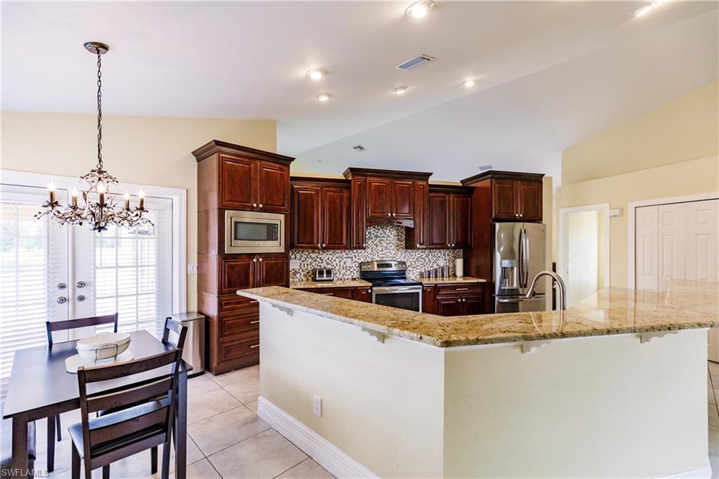 3881 Packinghouse Road Alva, FL 33920 - Photo 9 of 35 a kitchen with kitchen island granite countertop a stove and a sink