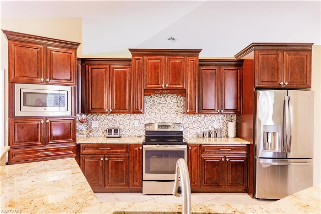 3881 Packinghouse Road Alva, FL 33920 - Photo 10 of 35 a kitchen with stainless steel appliances granite countertop a refrigerator and a stove top oven