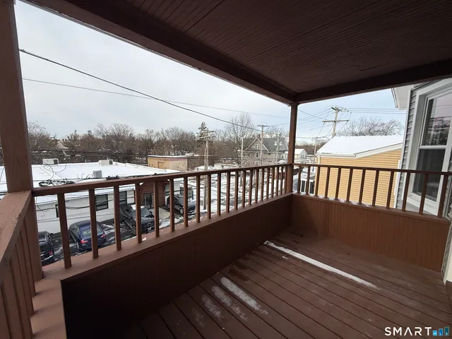a view of roof deck with wooden floor and fence