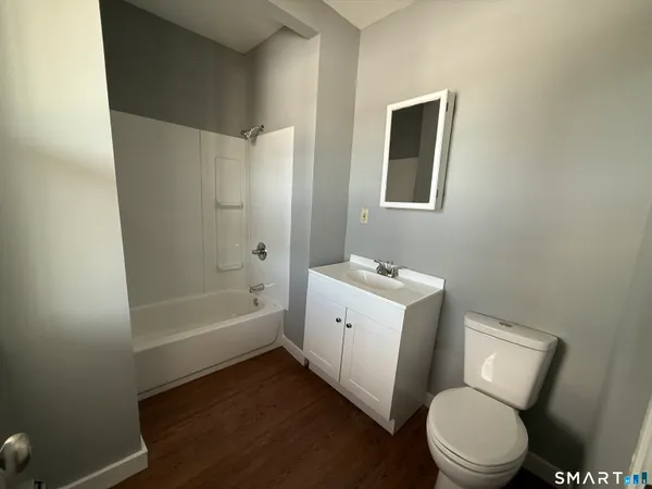 a white toilet sitting next to a bath tub