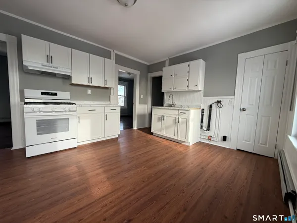 a kitchen with stainless steel appliances a stove top oven and white cabinets