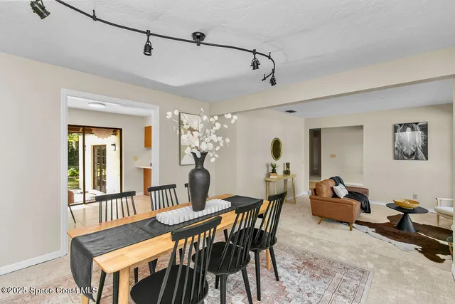 a large kitchen with a counter top space a sink a stove a refrigerator and a living room view