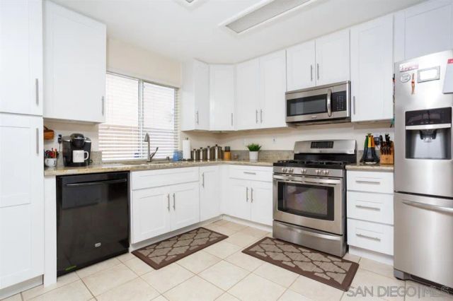 a kitchen with cabinets stainless steel appliances and window