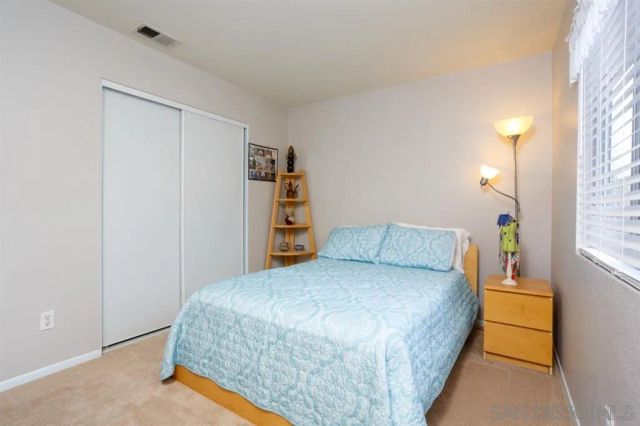 a bedroom with a bed and a night stand