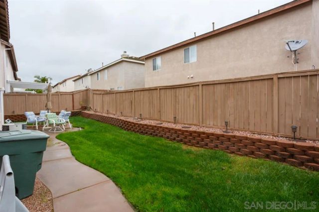 a backyard of a house with garden and wooden fence