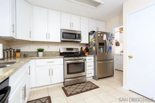 a kitchen with stainless steel appliances granite countertop a refrigerator stove and sink